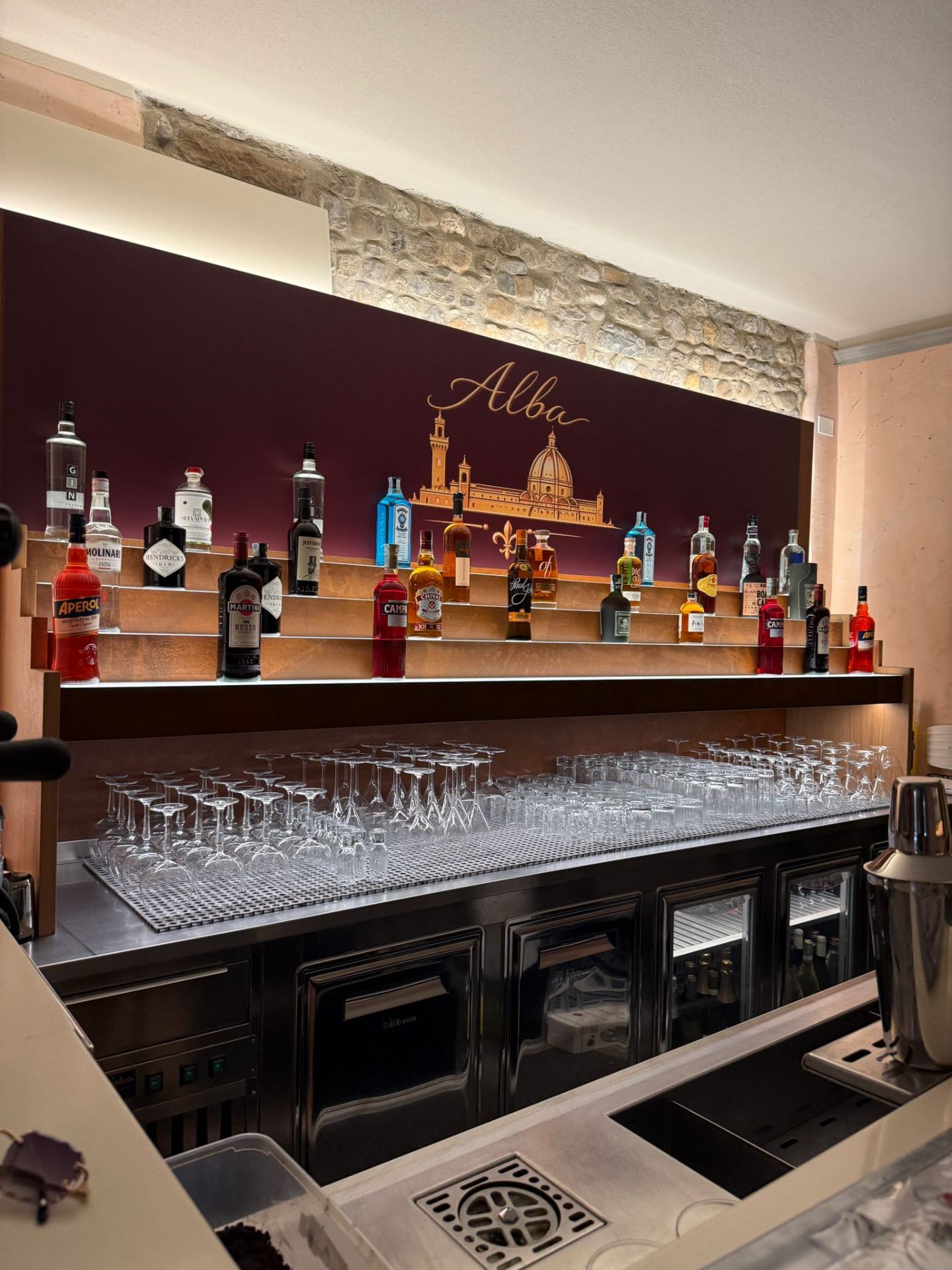 Lounge bar con bottiglie e fondale bordeaux — Alba Firenze